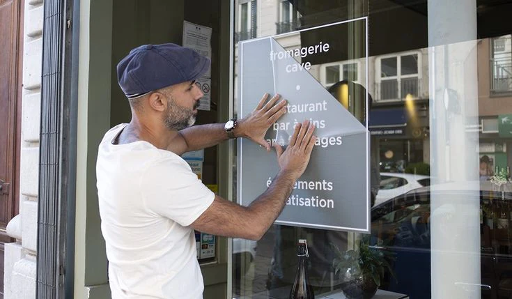 pose autocollant sans bulle sur vitrine magasin